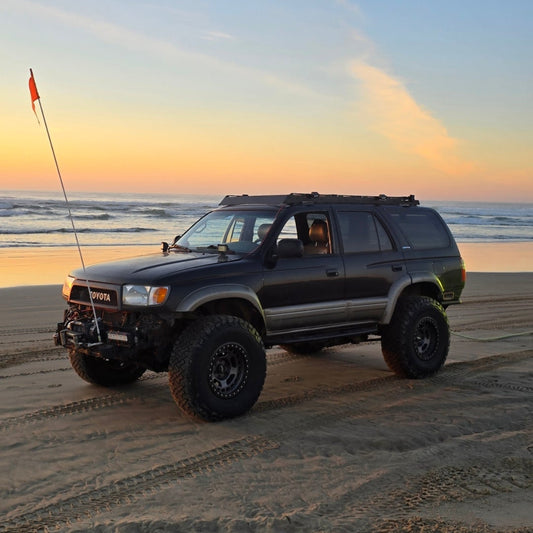 3rd gen 4runner on a sandy beach with a revo systems roof rack